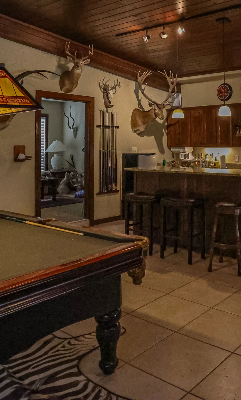 Pool table and bar inside the wood-paneled Agua Vida Ranch lodge